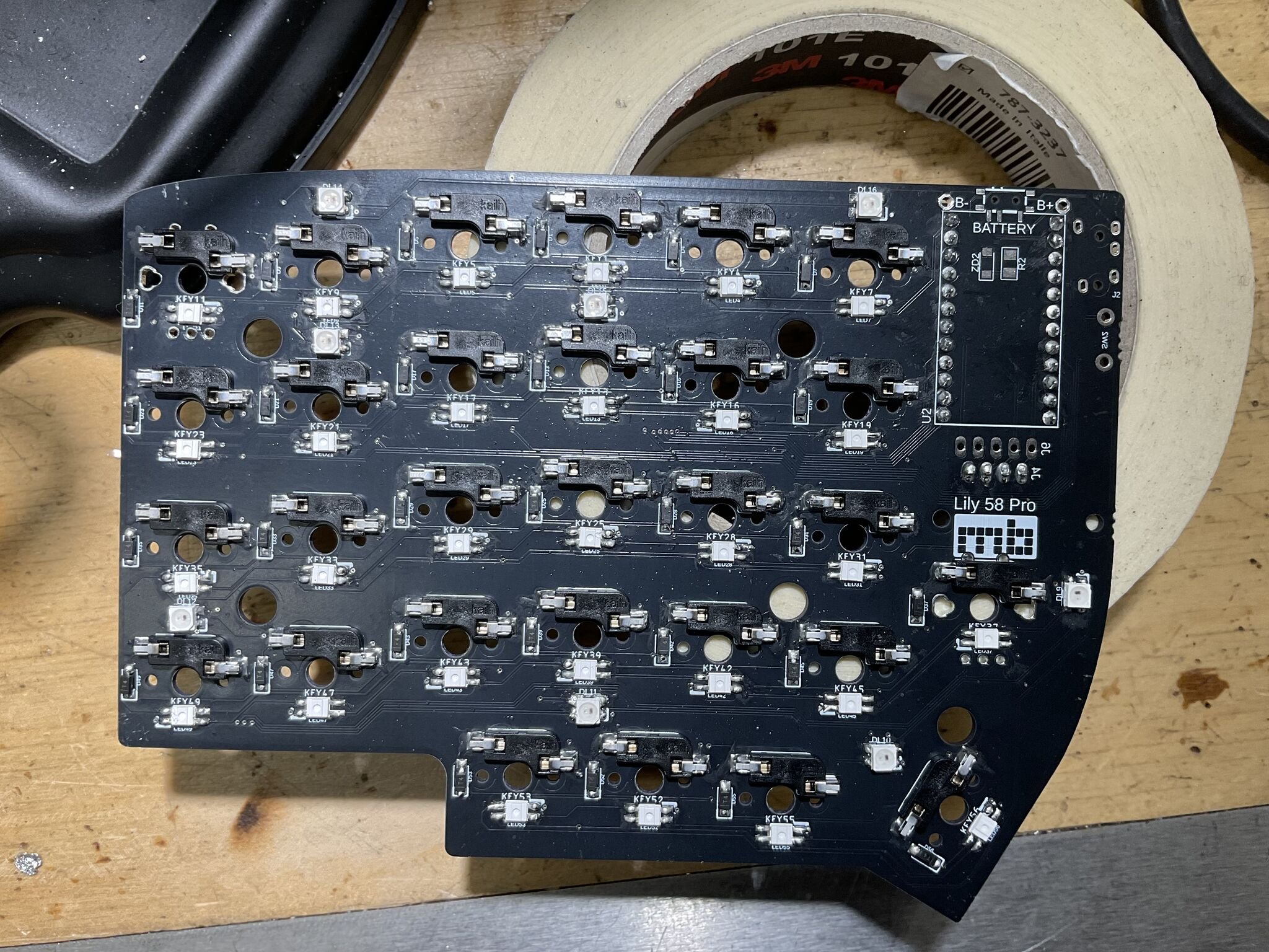 A close-up of one half during the SMD diode and LED stage. You can see the Kailh hot-swap sockets, the per-switch LED pads (the small square footprints near each socket), and the diode pads on the right side of each switch.